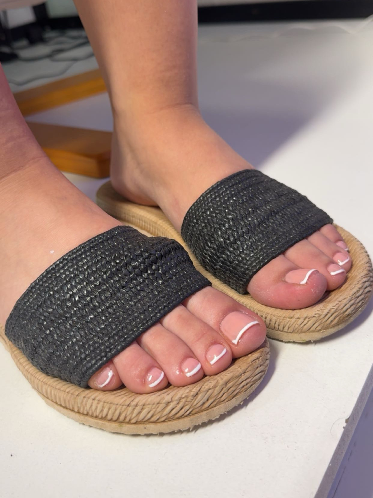 Teennagels in french gellak in een zwarte sandaal
